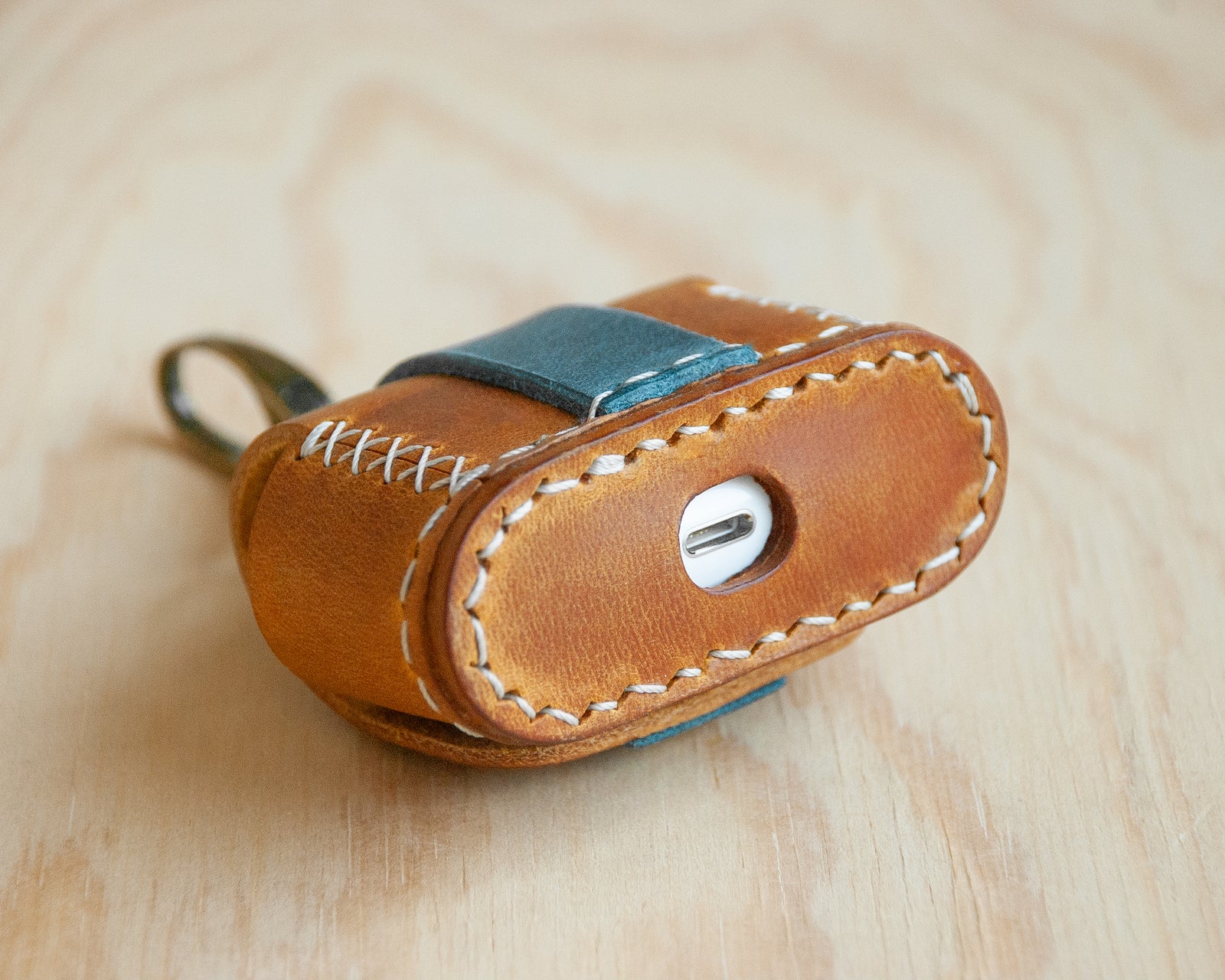 Handmade leather AirPods case close-up, oil-waxed cowhide