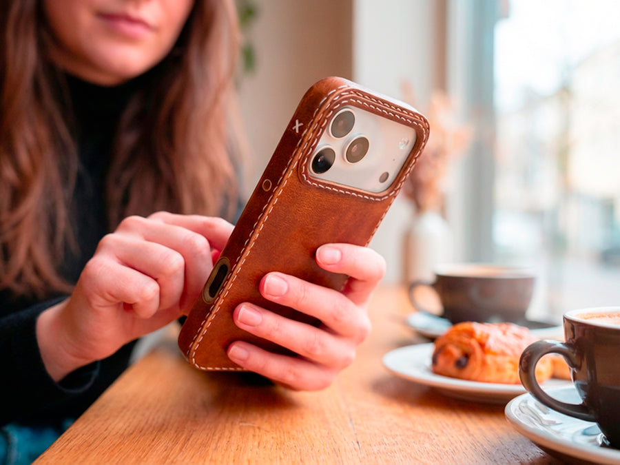TRIM Ember leather iPhone case on café table